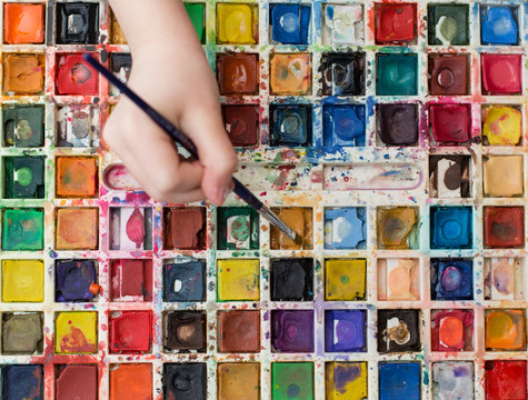 closeup of watercolor paints with hands