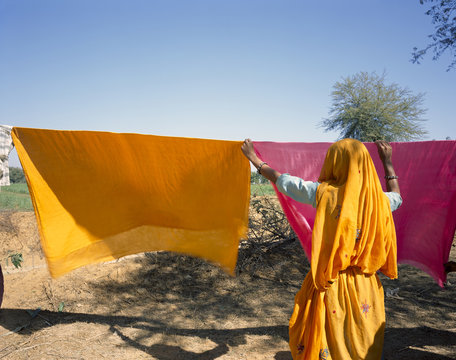 Indian woman wearing sari drying clothes. Rajasthan. India