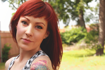 Smiling Young Redhead with Tattoos Outside
