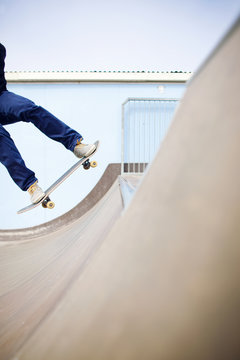 Young man landing a skateboard trick in a skate park on a sunny day