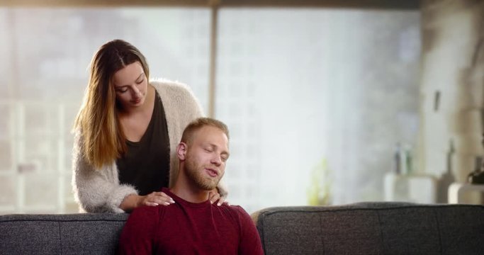 Young woman gives his boyfriend a beautiful neck massage