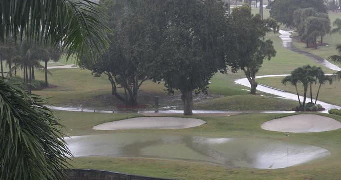A tropical rain storm soaks a golf course fairway in Miami Florida USA