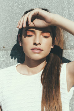 Sunlit portrait of a young woman with closed eyes