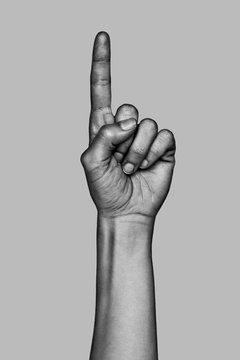Hand making the number one sign. Black and white photo.
