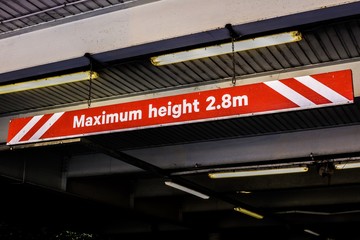 Sign: Maximum Height 2.8m, red and white, hanging from carpark ceiling