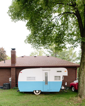 vintage camper parked by house