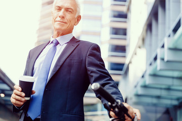 Successful businessman riding bicycle