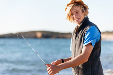Teenage boy fishing at sea