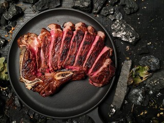 The steak is cut and lies in a frying pan. - 165130792