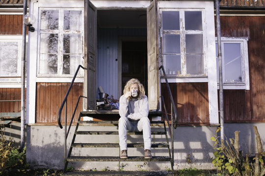Young man enjoying his coffee outside in the sun.