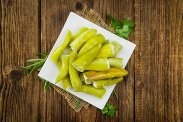 Green Chilis (filled with cheese) on wooden background (selective focus)