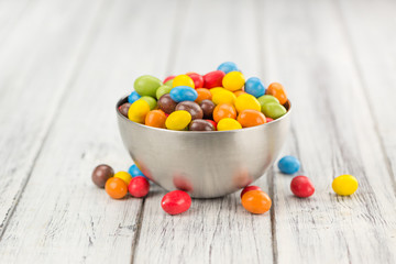 Cocolate coated Peanuts on wooden background (selective focus)
