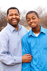 Happy African American father and son talking and laughing.