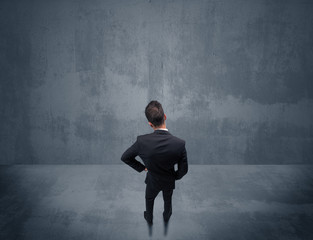 Businessman standing in front of urban wall