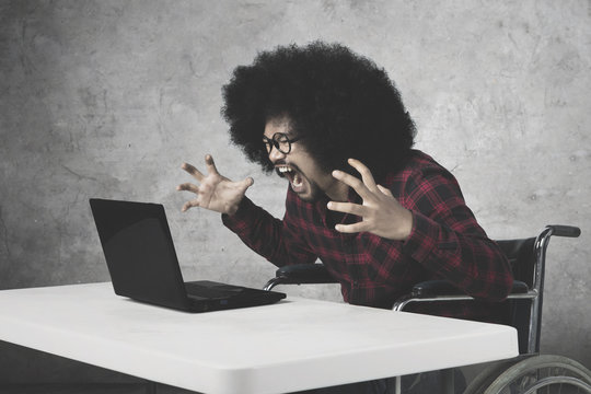 African businessman shouting at his laptop
