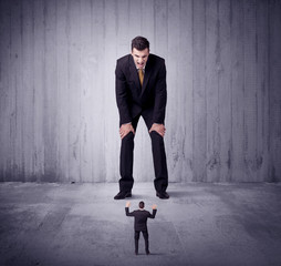 Obraz premium Huge boss lokking at small business man