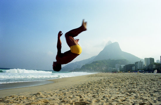 Man back flipping on beach. Ipanema. Rio de Janeiro. Brazil