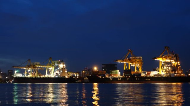 Container loading by crane, cargo ship at shipping port at twilight, Logistics and transportation concept. Time lapse