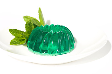 Green mint jelly   on a white plate on a white background. Summer cooling dessert