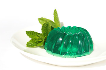 Green mint jelly close-up on a white plate on a white background. Summer cooling dessert