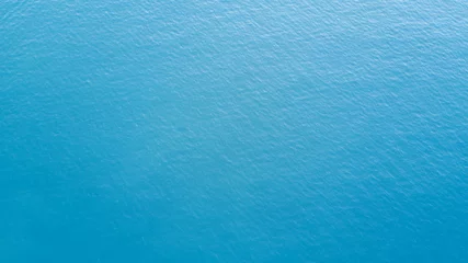 Poster Diepblauwe oceaan met kalme golf © Creativa Images