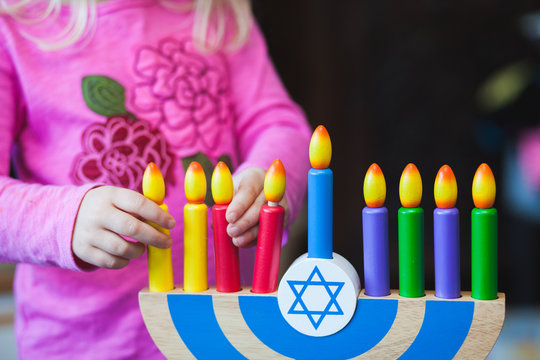 Child playing with toy Menorah.