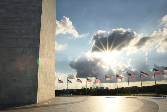 Washington Monument Wall and american flags during sunset