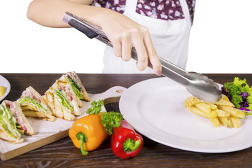 Female chef preparing sandwich