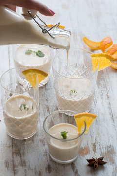 A Woman Pours Eggnog Into Glasses