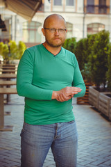 A mature alone man hipster in shirt and jeans shorts in European cafe and reflects on the frailty of life