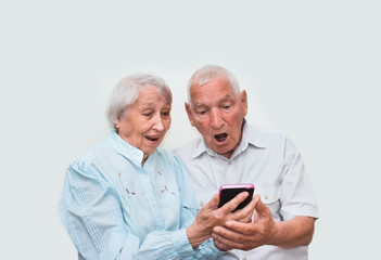 Senior couple at home using smartphones