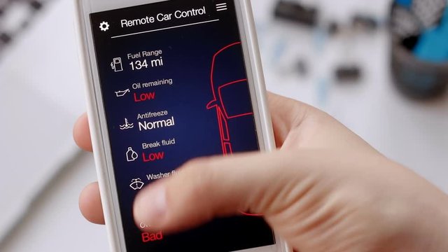Man checks car information on his mobile device. Bad condition, car need repair. Car remote control using smartphone application fictional interface.