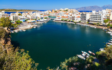 Panorama of Agios Nikolaos or Ayios, Aghios town in Crete, Greece. Showing famous places: Lake, Marina, Bay, Old town.