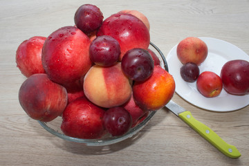 Nectarine, peaches and plums with water drops on wood table. fruit on the table