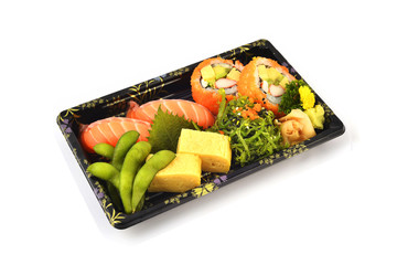 Salmon Sushi and California Maki  and Tamoko tamago fill with Pigeon pea and spicy Seaweed salad Japanese tradition food in delivery low cost box set