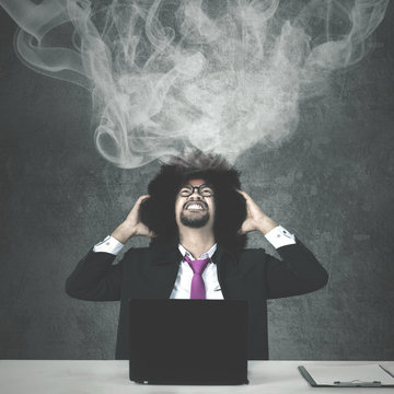 Stressful businessman with smoke over his head