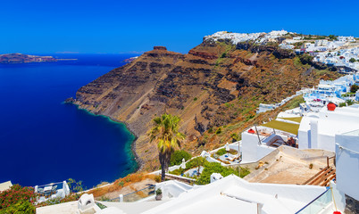 Obraz premium Hotels of Fira town on slopes of volcanic mountain overlooking sea and Caldera of Santorini, Greece.