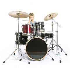 Fototapeta na wymiar young caucasian boy plays drums in studio against white background