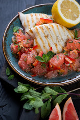Roasted calamari served with grapefruit salad, vertical shot, selective focus