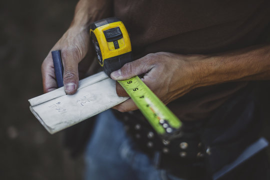 worn hands working out math for carpentry renovation