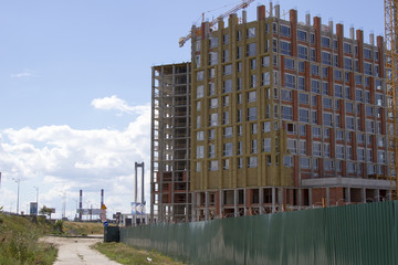 Crane and building under construction against blue sky
