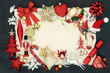 Christmas background border with bauble decorations, holly, mistletoe and ornaments on parchment...