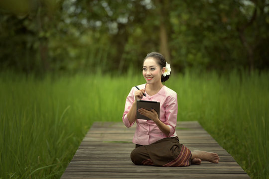 The girl plays a taplet in a native dress.
