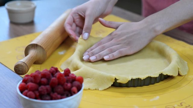 A woman making a crust for a tart. Making tart dough
