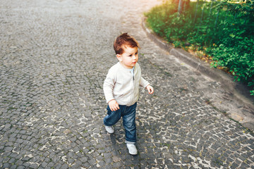 Pretty little boy walking alone on the street
