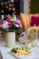 Brautstrauß auf Tisch mit Sekt, Gläser, Weintrauben und Käse Sticks