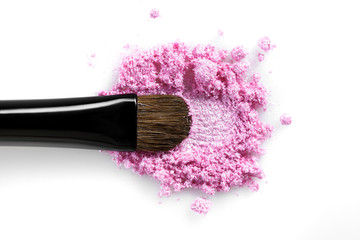 Broken pink eye shadow and brush isolated on white background