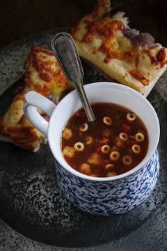 A cup of Minestrone soup with mozarella and red onion focaccia bread shot with low key lighting 