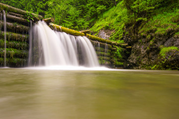 Beautiful typical waterfall on the river at the Kvačany mill in the mountains in Slovakia
