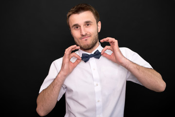 A man in a white shirt holds a butterfly in his hands and smiling